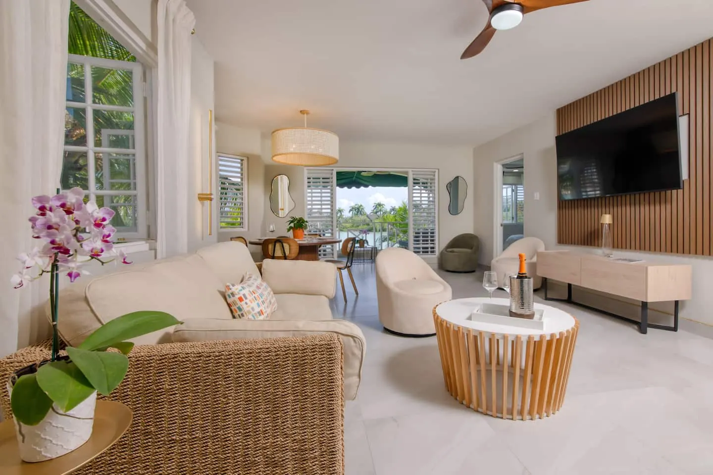 Living and dining area overlooking the lagoon, with sofa seating and TV.