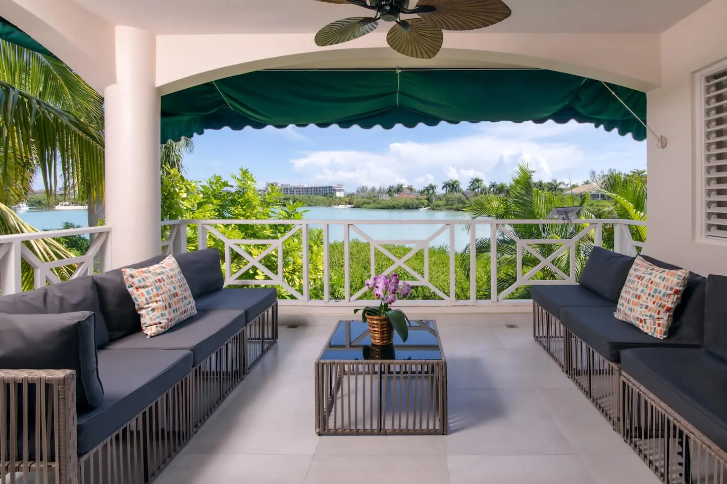 Covered balcony with outdoor sofas and lagoon views.